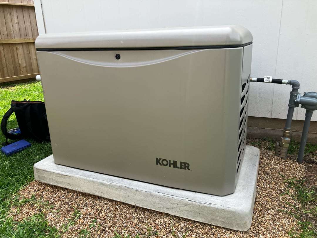 A Kohler air-cooled standby generator set on a poured concrete pad at a Fort Bend County home