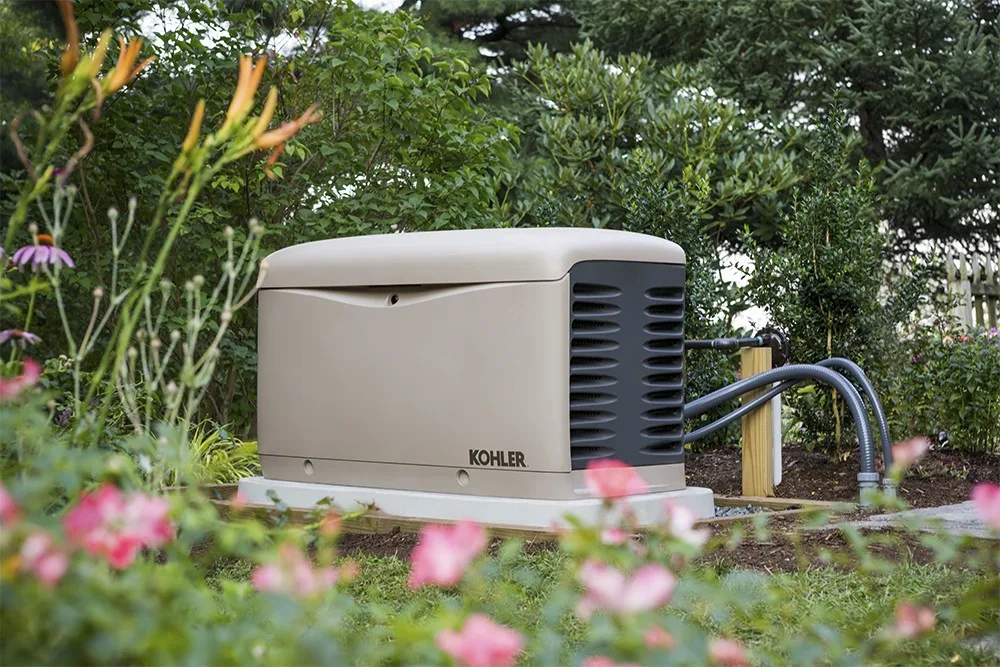 A certified technician installing a KOHLER standby generator outside a modern U.S. home, representing nationwide service coverage.